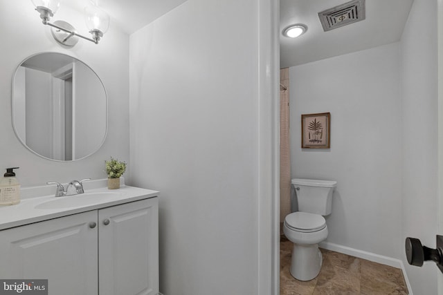 full bath with toilet, vanity, and baseboards