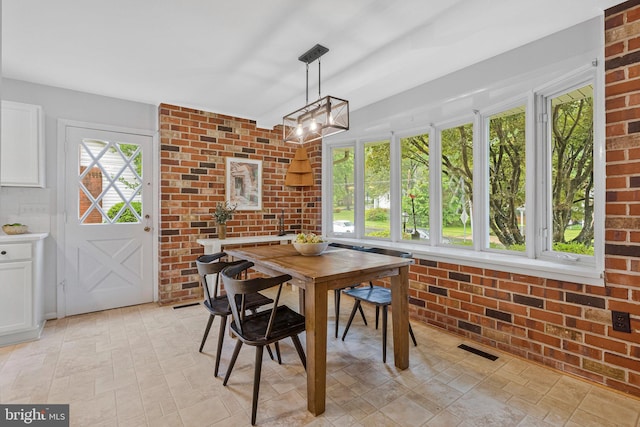 dining space featuring brick wall