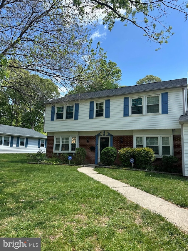 view of front of house featuring brick siding and a front lawn