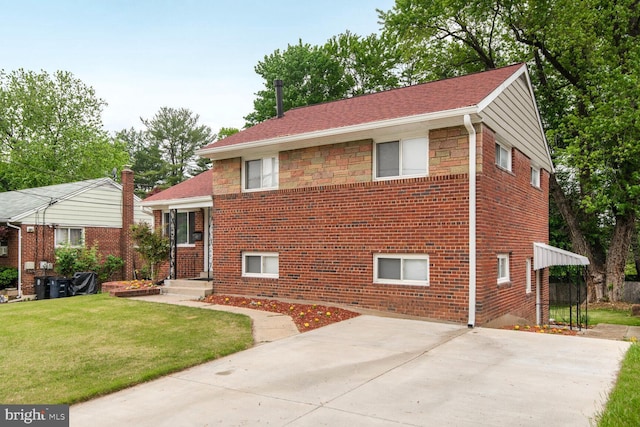 tri-level home featuring a front yard and brick siding