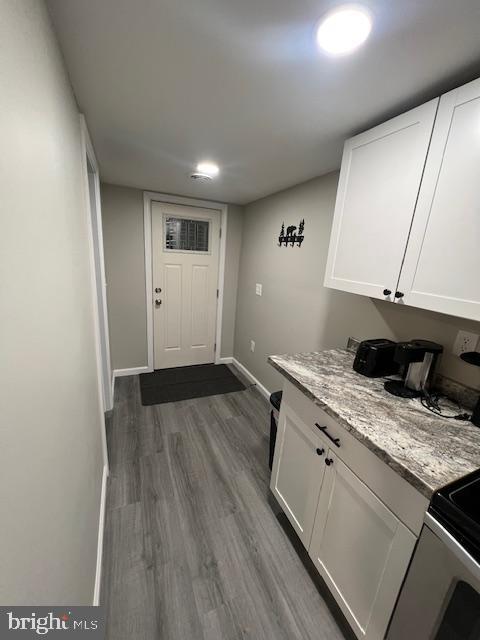 washroom featuring laundry area, dark wood finished floors, and baseboards