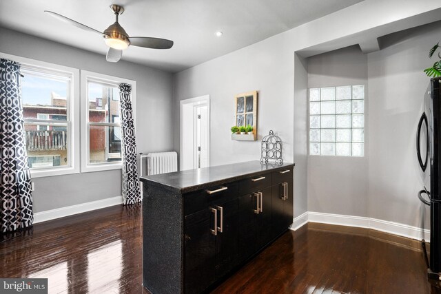 3700 13th St NW, Washington, DC 20010 - kitchen with dark cabinetry, freestanding refrigerator, ceiling fan, radiator, and dark wood-style flooring