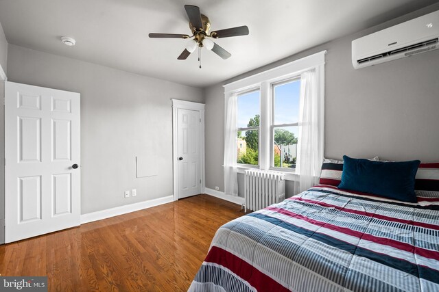 3700 13th St NW, Washington, DC 20010 - bedroom featuring radiator, a wall unit AC, wood finished floors, and ceiling fan