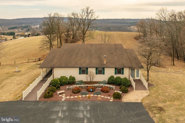 view of front of property with a rural view, driveway, and stairs
