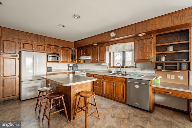 kitchen with brown cabinets, appliances with stainless steel finishes, and a sink