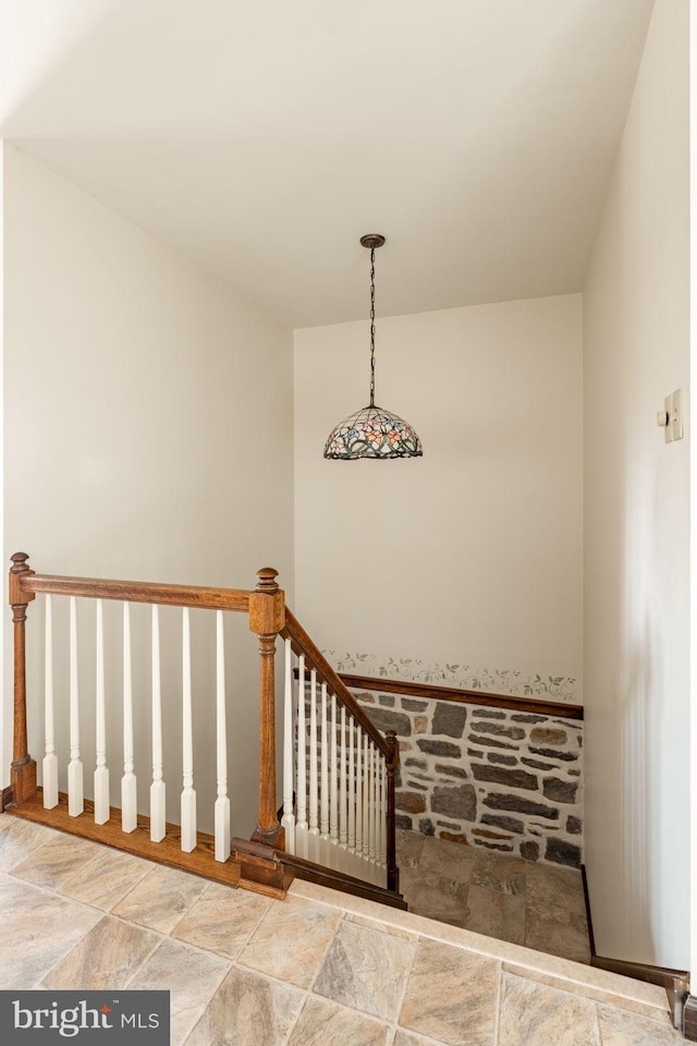 staircase featuring stone finish floor