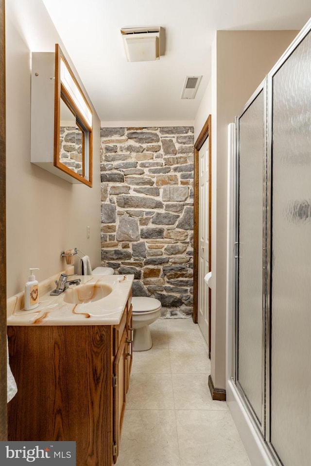 bathroom featuring a shower stall, toilet, vanity, and visible vents