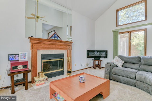 living area featuring ceiling fan, carpet floors, baseboards, high vaulted ceiling, and a glass covered fireplace