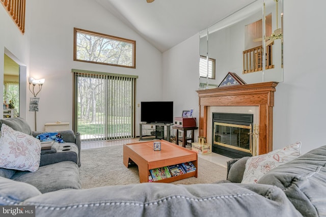 carpeted living area featuring high vaulted ceiling and a glass covered fireplace