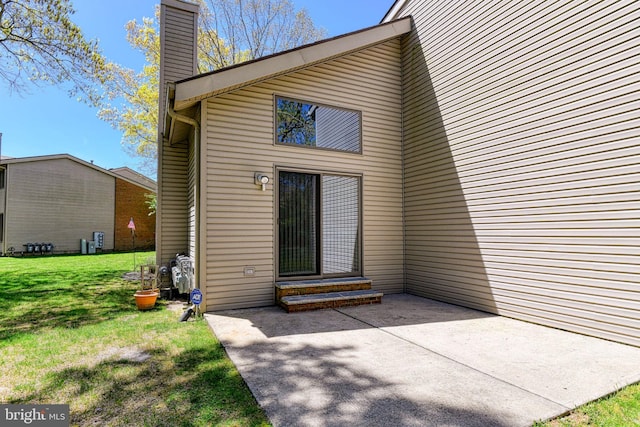 rear view of house with a yard, a patio, and a chimney