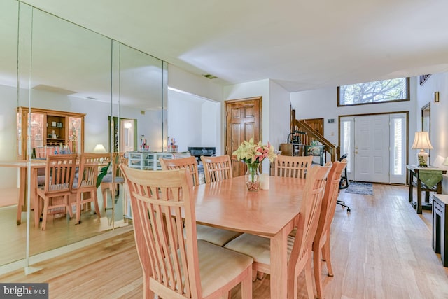 dining area featuring visible vents, stairway, and light wood-type flooring