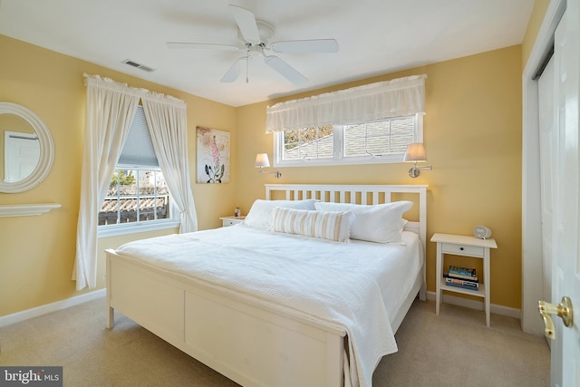 bedroom with a ceiling fan, visible vents, baseboards, a closet, and light carpet