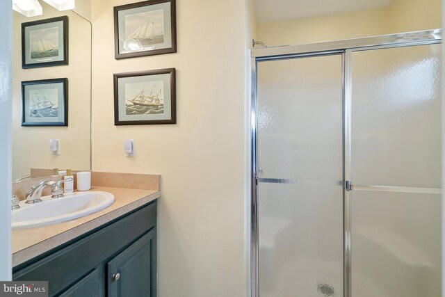 full bath with a shower stall and vanity