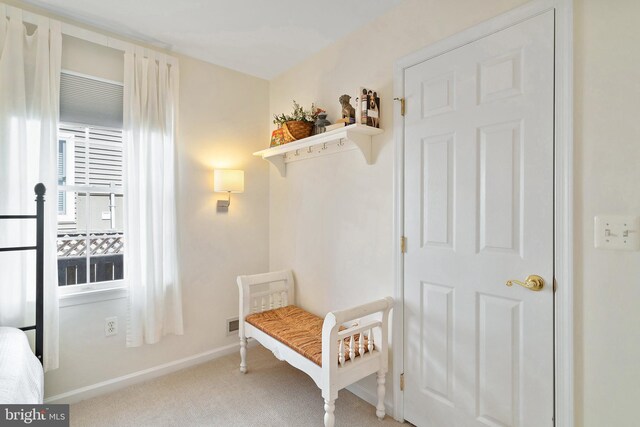 mudroom featuring baseboards and light colored carpet