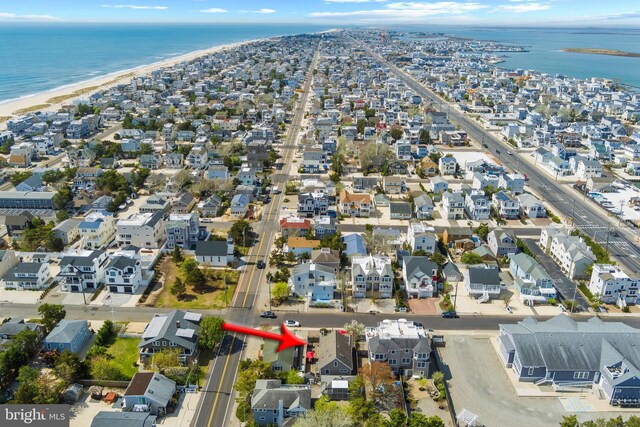 birds eye view of property with a water view, a view of the beach, and a residential view