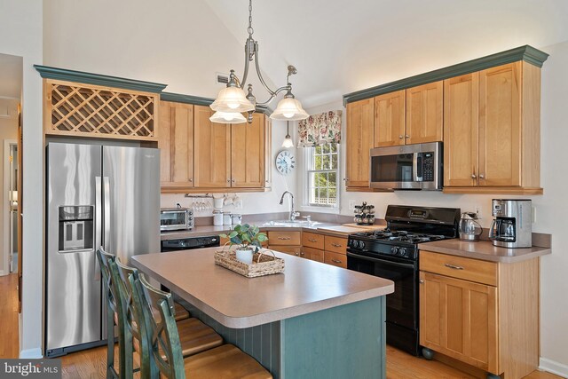 kitchen featuring a kitchen island, a breakfast bar area, light wood-type flooring, a sink, and stainless steel appliances