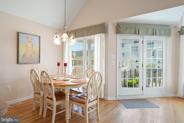 dining area featuring an inviting chandelier, baseboards, wood finished floors, and visible vents
