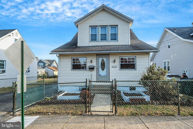 bungalow-style house with a gate, a fenced front yard, and roof with shingles