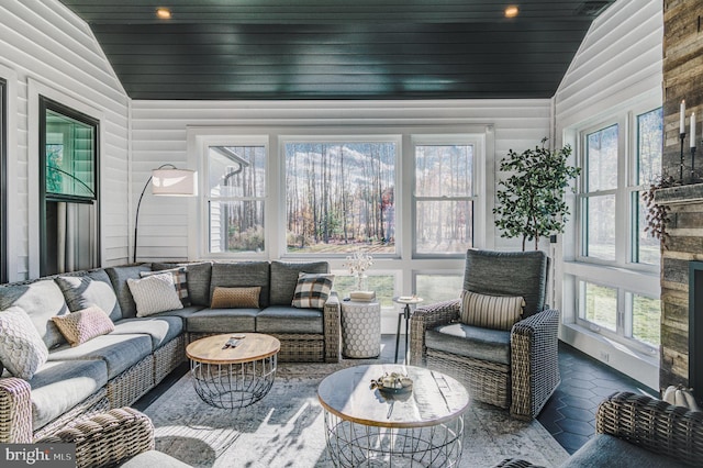 sunroom with a healthy amount of sunlight, wood ceiling, and lofted ceiling
