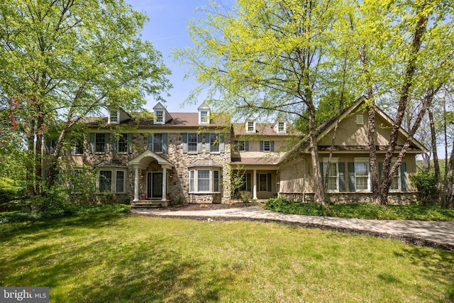 view of front of property with stone siding, stucco siding, and a front lawn