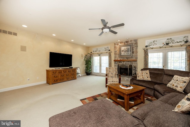 living area with a ceiling fan, baseboards, visible vents, a fireplace, and carpet floors