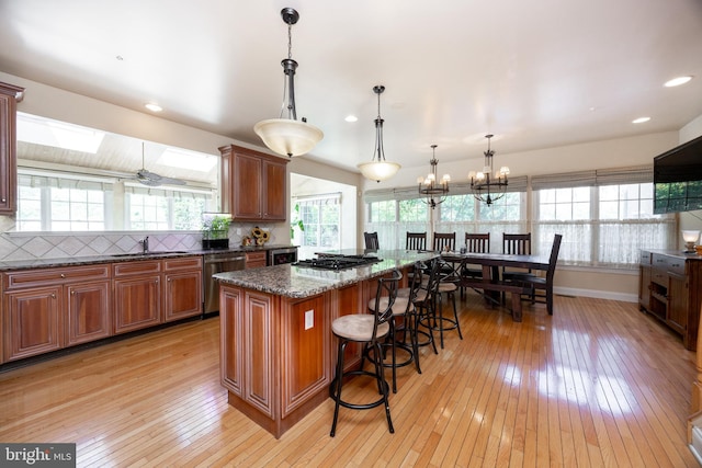 kitchen with light wood-style floors, a healthy amount of sunlight, and stainless steel dishwasher