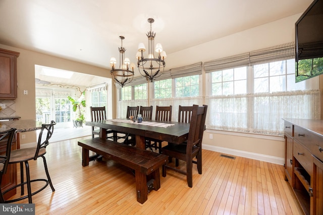 dining area with visible vents, baseboards, a skylight, and light wood-style flooring