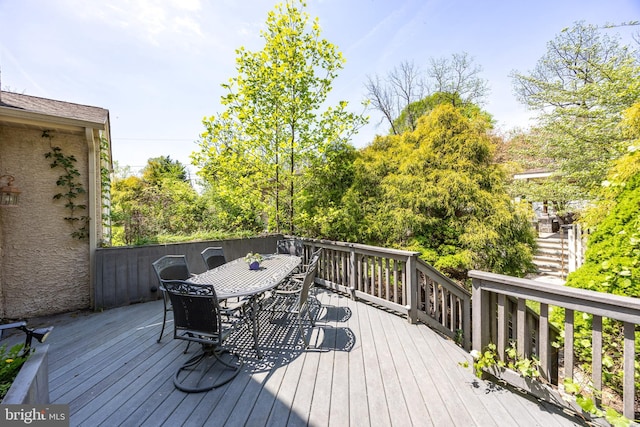 deck featuring stairway and outdoor dining area