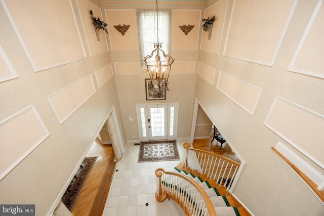 foyer with stairs, a notable chandelier, and tile patterned floors