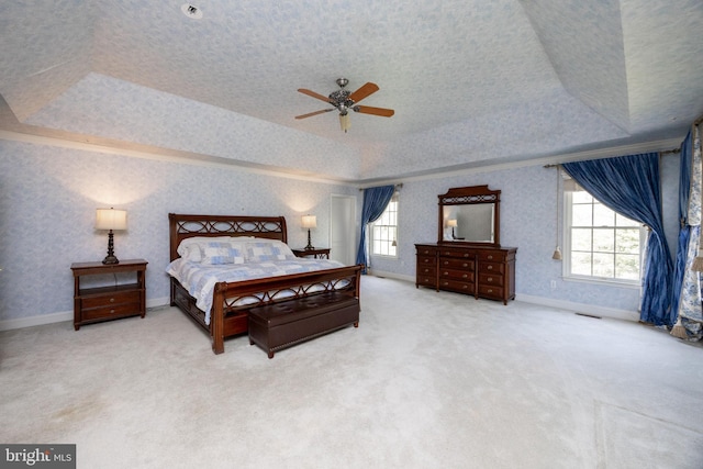bedroom featuring a raised ceiling, carpet flooring, and multiple windows