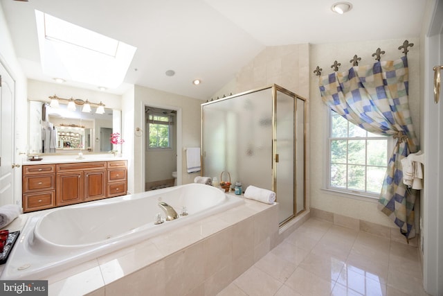 bathroom with toilet, lofted ceiling with skylight, a garden tub, and a shower stall