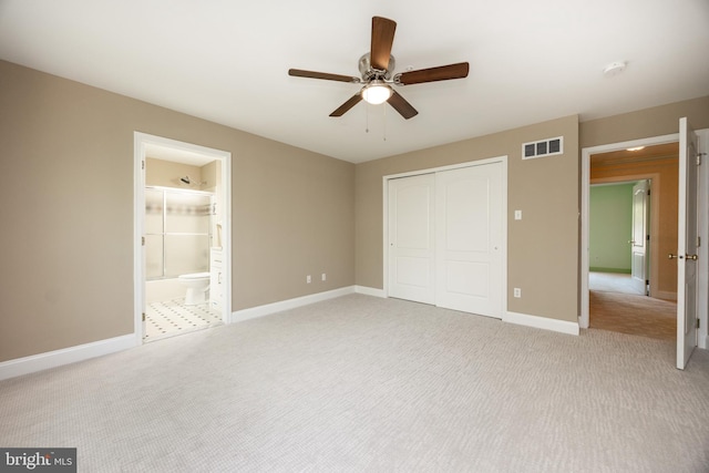 unfurnished bedroom with a closet, baseboards, ceiling fan, visible vents, and light carpet