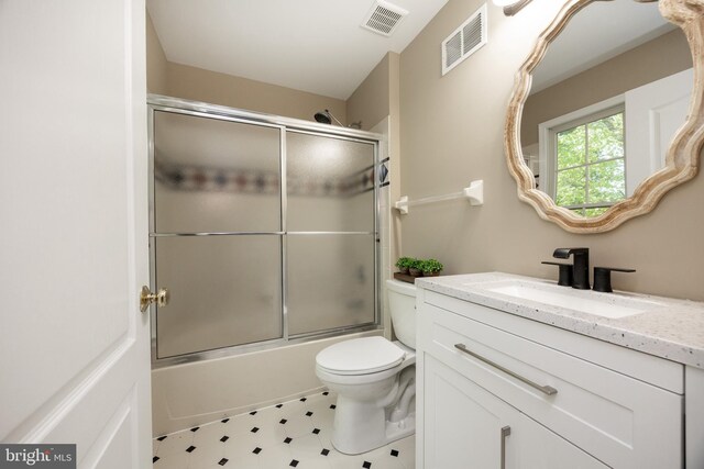 full bathroom featuring toilet, vanity, visible vents, and enclosed tub / shower combo