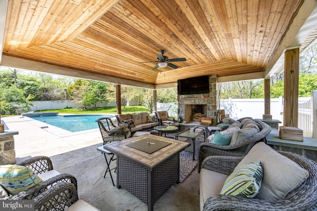 view of patio featuring an outdoor living space with a fireplace, a ceiling fan, a fenced in pool, and a fenced backyard