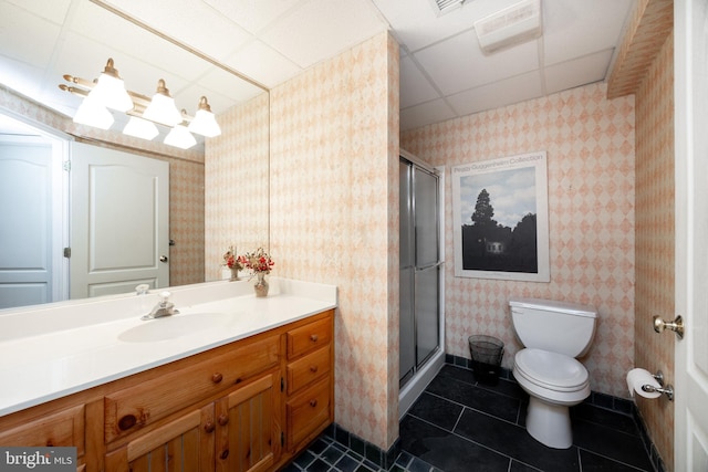 bathroom featuring wallpapered walls, toilet, a drop ceiling, and a stall shower