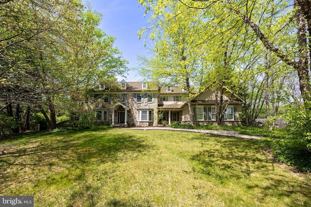 view of front of home featuring stone siding and a front lawn