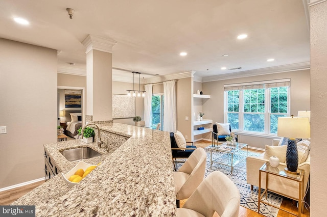1530 Spring Gate Dr Unit 9208, Mclean, VA 22102 - kitchen with a sink, ornamental molding, light wood-style floors, baseboards, and light stone countertops