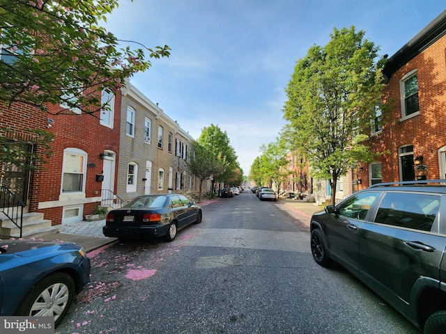 view of street with a residential view, sidewalks, and curbs