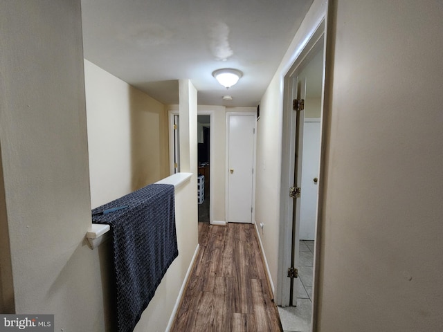hall featuring baseboards and wood finished floors