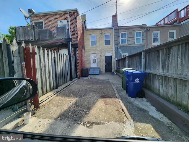 view of front facade with brick siding, central AC unit, and fence