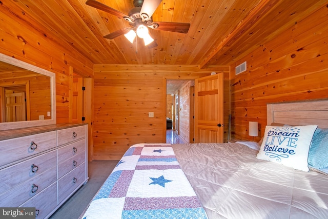 bedroom featuring wooden walls, wood ceiling, and dark carpet