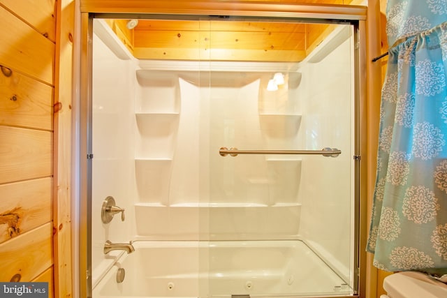 bathroom with toilet and shower / bath combination with glass door