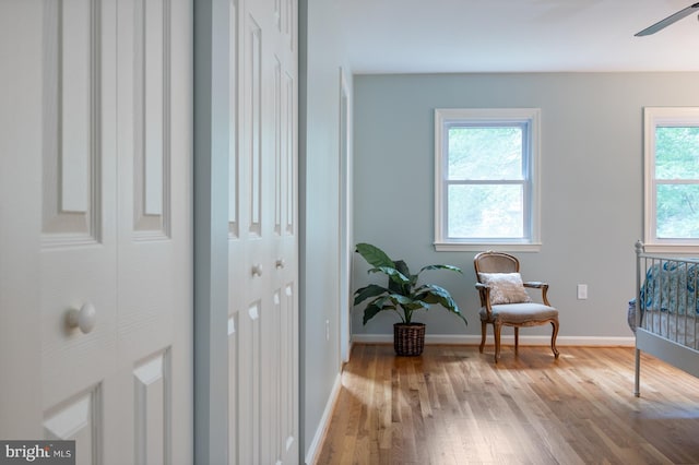 sitting room featuring a ceiling fan, wood finished floors, and baseboards