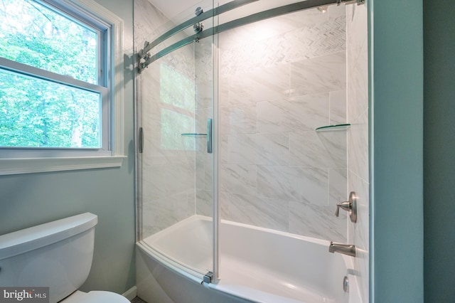 full bathroom featuring a wealth of natural light, toilet, and combined bath / shower with glass door