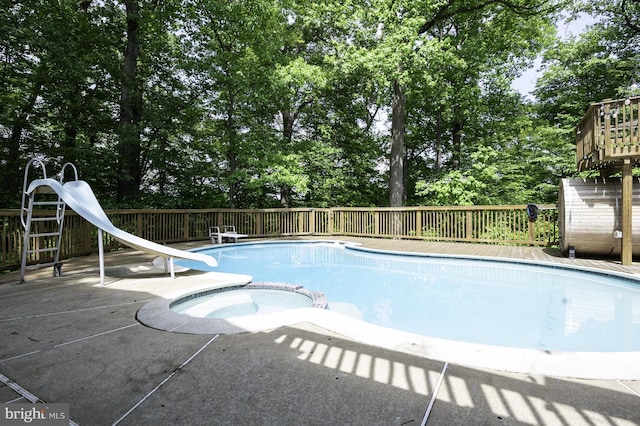 view of pool with a patio, a pool with connected hot tub, and a water slide
