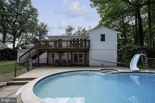 view of swimming pool featuring french doors, fence, stairs, a deck, and a water slide