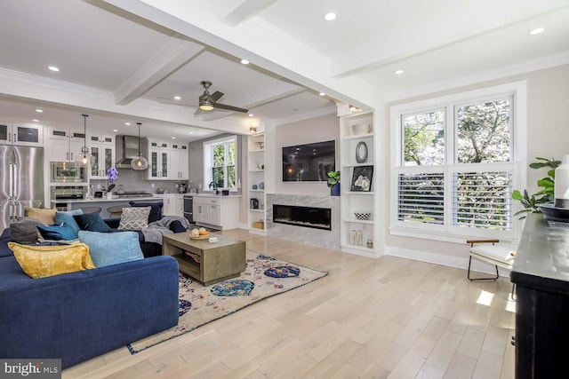 5116 Lawton Dr, Bethesda, MD 20816 - living room with ornamental molding, beam ceiling, a fireplace, a ceiling fan, and light wood-style floors