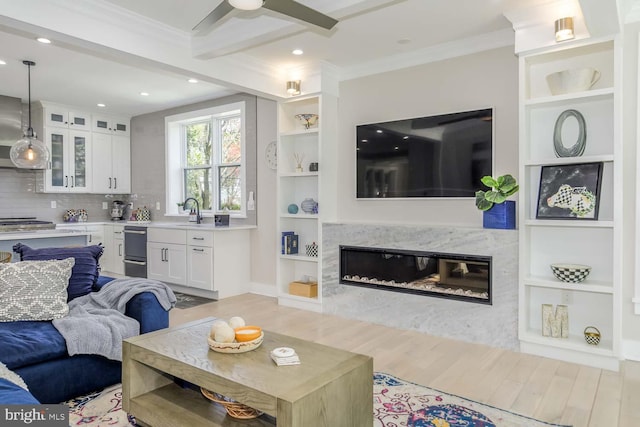 5116 Lawton Dr, Bethesda, MD 20816 - living room with ornamental molding, wood finished floors, recessed lighting, built in features, and a high end fireplace