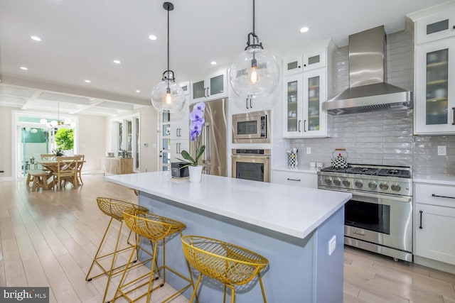 5116 Lawton Dr, Bethesda, MD 20816 - kitchen featuring high quality appliances, wall chimney exhaust hood, light countertops, light wood-type flooring, and recessed lighting