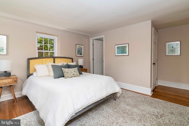 bedroom with baseboards and wood finished floors